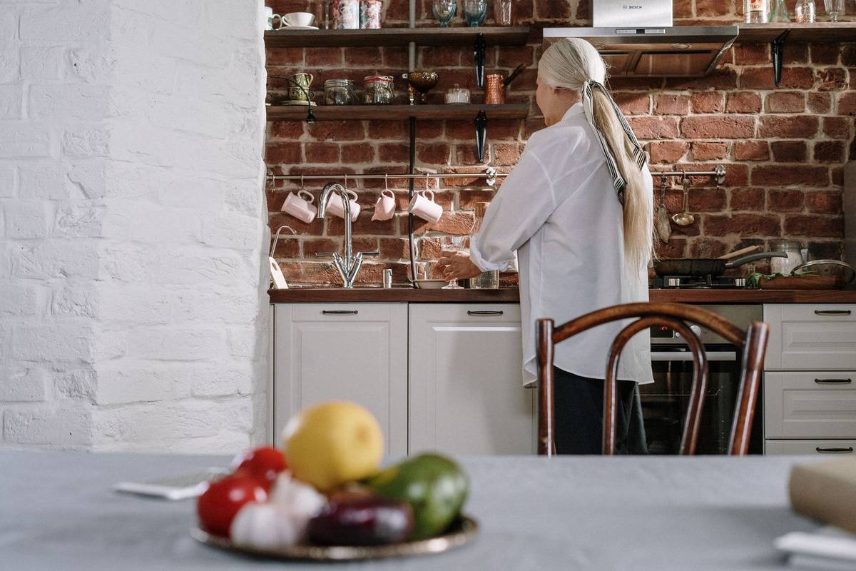 Senior woman cooking with fresh vegetables in a bright kitchen